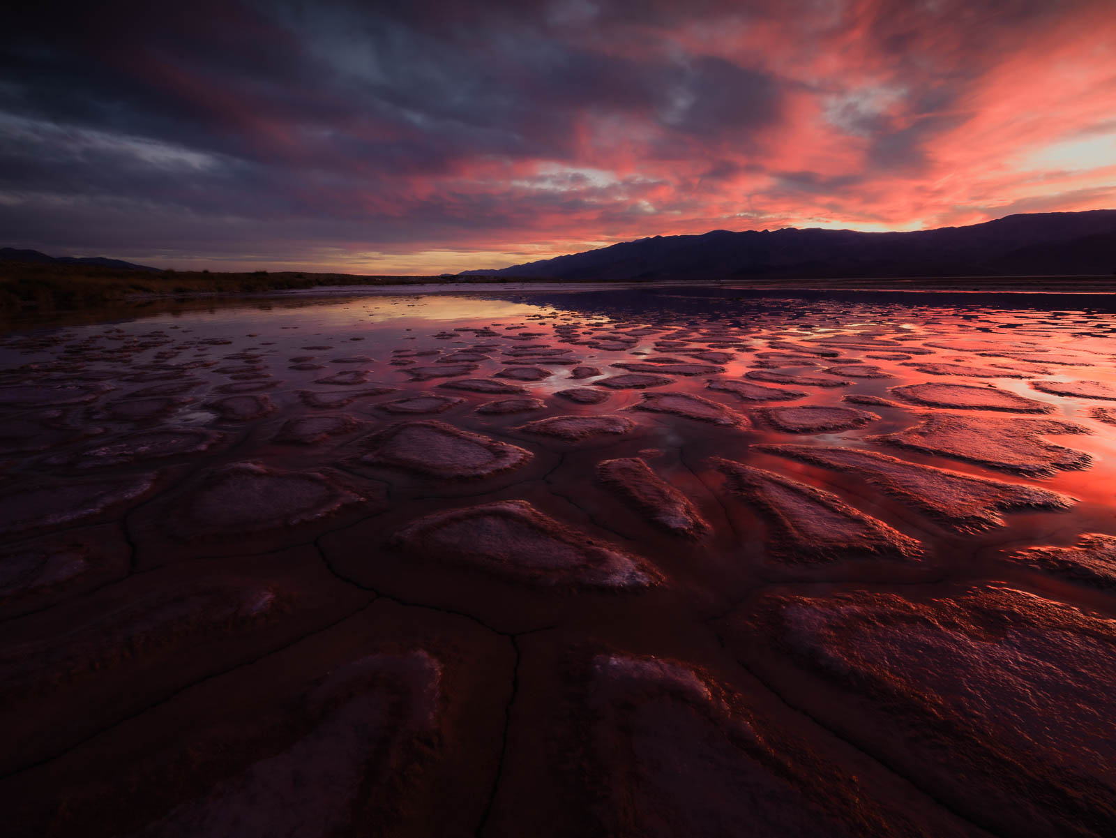 An incredible sunset erupts over a playa in Death Valley.