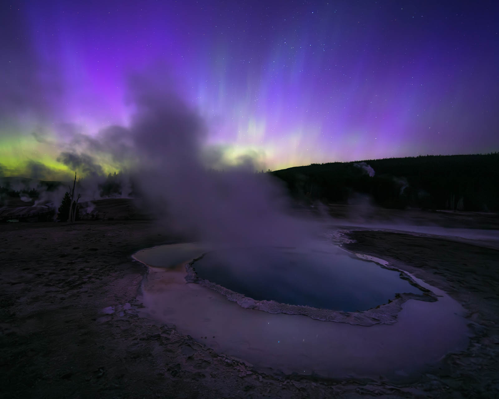 Reflecting Pool aurora borealis in yellowstone national park over crested pool in the upper geyser basin