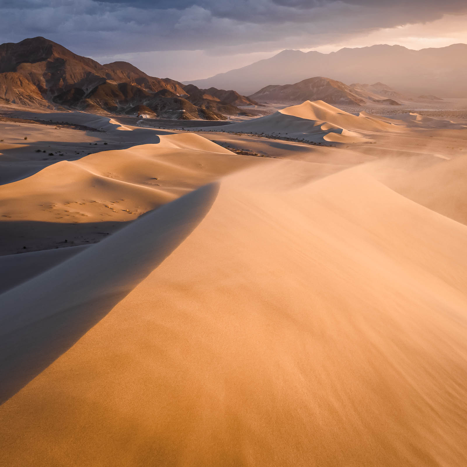 A remote set of sand dunes in Death Valley National Park at sunset.